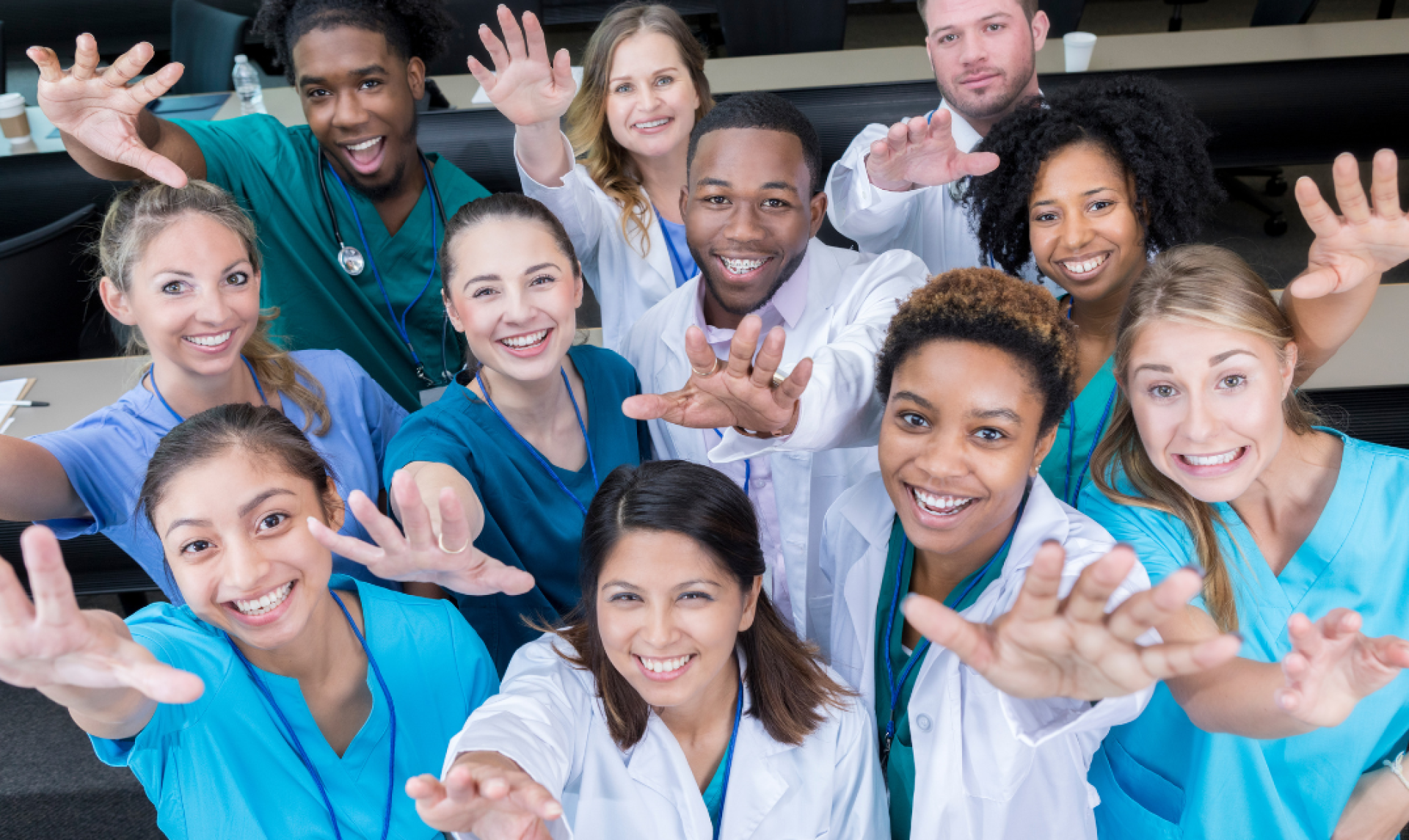 A group of health professionals from many fields reach out to the camera