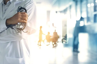 Doctor with faded color-filtered background of health professionals working